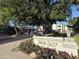 Inviting condo entrance with blooming flowers, lush trees, and gated entry for a secure and picturesque welcome at 5201 N 24Th St # 107, Phoenix, AZ 85016