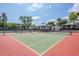 Outdoor tennis court on a sunny day with a red and green court with nets ready for a game at 5201 N 24Th St # 107, Phoenix, AZ 85016