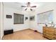 A modest bedroom includes a ceiling fan, a window with wood blinds, and a light wood floor at 5210 W Ironwood Dr, Glendale, AZ 85302