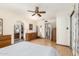 Bedroom with a ceiling fan, wood-look floors, and ensuite bathroom access at 5210 W Ironwood Dr, Glendale, AZ 85302