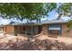 Inviting home featuring blue shutters, brick accents, and a cozy front porch seating area at 5210 W Ironwood Dr, Glendale, AZ 85302