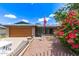 Charming brick home featuring an American flag, desert landscaping, and beautiful bougainvillea at 5210 W Ironwood Dr, Glendale, AZ 85302