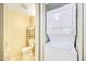A compact, tiled bathroom showcases a toilet and stacked washer/dryer for convenience at 5735 E Mcdowell Rd # 67, Mesa, AZ 85215