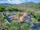 Stunning aerial view of a desert home, featuring a pool, tile roof, and solar panels against a mountain backdrop at 6524 E Rockaway Hills Dr, Cave Creek, AZ 85331