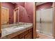 Bathroom featuring granite countertops, wooden cabinets, a mirror and a tiled walk-in shower at 6524 E Rockaway Hills Dr, Cave Creek, AZ 85331