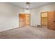 Bright bedroom featuring carpet, ceiling fan, and wood-trimmed doors with walk-in closet at 6524 E Rockaway Hills Dr, Cave Creek, AZ 85331