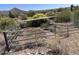 View of the fenced-in horse property with a covered shelter and desert views beyond at 6524 E Rockaway Hills Dr, Cave Creek, AZ 85331