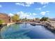 Large backyard swimming pool with rock waterfall and outdoor fireplace, perfect for entertaining at 6524 E Rockaway Hills Dr, Cave Creek, AZ 85331