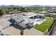 Stunning aerial view of a modern home with a pool, manicured lawn, and mountain views at 6614 E North Ln, Paradise Valley, AZ 85253