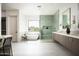 Modern bathroom featuring dual sinks, soaking tub, glass-enclosed shower, and window at 6614 E North Ln, Paradise Valley, AZ 85253