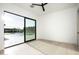 An empty room with hardwood floors, a ceiling fan, and an expansive window overlooking the backyard at 6614 E North Ln, Paradise Valley, AZ 85253