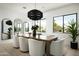 Dining room with modern decor, decorative lighting, large windows and seating for eight at 6614 E North Ln, Paradise Valley, AZ 85253