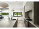 Modern kitchen island with sink, stainless steel appliances, and large windows that overlook a beautiful backyard at 6614 E North Ln, Paradise Valley, AZ 85253