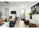 Bright living room features white walls, modern furnishings, and an open doorway to the outside at 6614 E North Ln, Paradise Valley, AZ 85253