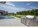 Outdoor kitchen featuring a stainless steel grill, counter space, and serene pool views at 6614 E North Ln, Paradise Valley, AZ 85253