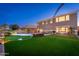 Lush backyard featuring a pool with waterfalls, manicured lawn, and outdoor seating area at 6621 S Balboa Dr, Gilbert, AZ 85298