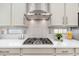 Close-up of the kitchen with a stovetop, stainless steel hood, and modern countertops at 6621 S Balboa Dr, Gilbert, AZ 85298