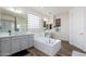 Bright main bathroom with dual sinks, a soaking tub, and modern fixtures at 6621 S Balboa Dr, Gilbert, AZ 85298