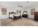 Spacious main bedroom with a large bed, dark wood furniture, and ample natural light at 6621 S Balboa Dr, Gilbert, AZ 85298