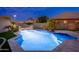 Stunning backyard pool with water features surrounded by lush landscaping at twilight at 6621 S Balboa Dr, Gilbert, AZ 85298