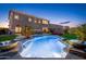 Backyard view of a pool with water features, lounge area, and well-manicured landscaping at dusk at 6621 S Balboa Dr, Gilbert, AZ 85298