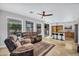 Open-plan living room featuring a kitchen island, ceiling fan, and backyard views at 6623 S Classic Way, Gilbert, AZ 85298