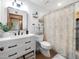 Updated bathroom with modern vanity, walk-in shower, black hardware, decorative mirror and neutral tiling at 6735 E San Juan Ave, Paradise Valley, AZ 85253