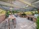 Outdoor kitchen featuring a grill, dining table and seating area, covered by a pergola at 6735 E San Juan Ave, Paradise Valley, AZ 85253