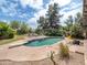 Backyard pool with surrounding patio and lounge chairs, set against a lush, green landscape at 6735 E San Juan Ave, Paradise Valley, AZ 85253