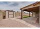 Low-maintenance backyard featuring a patio, storage shed, desert landscaping, and artificial turf at 7402 W Corrine Dr, Peoria, AZ 85381