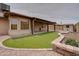 This landscaped backyard features artificial turf, desert rock and a covered patio at 7402 W Corrine Dr, Peoria, AZ 85381