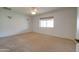 A well-lit bedroom with neutral carpet, ceiling fan, and a window providing natural light at 7402 W Corrine Dr, Peoria, AZ 85381
