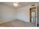 Bright bedroom featuring neutral carpet, ceiling fan, and convenient access to the hallway at 7402 W Corrine Dr, Peoria, AZ 85381