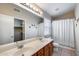 Bathroom with double sink vanity, large mirror, and shower with curtain at 7624 E Plata Ave, Mesa, AZ 85212