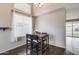 Bright dining area with a high ceiling, dark wood flooring, and a window with white curtains at 7624 E Plata Ave, Mesa, AZ 85212