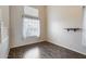 A spacious empty room with hardwood floors and a large window that lets in plenty of natural light at 7624 E Plata Ave, Mesa, AZ 85212