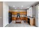 Well-lit kitchen with wooden cabinets, black appliances, granite countertops and a movable island at 7624 E Plata Ave, Mesa, AZ 85212