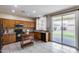 Eat-in kitchen with tiled floors, wooden cabinets and black appliances, leading to the backyard at 7624 E Plata Ave, Mesa, AZ 85212