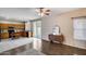 Open-concept living room and kitchen area with tile and wood flooring, ceiling fan, and sliding door access to the patio at 7624 E Plata Ave, Mesa, AZ 85212