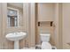 Powder room featuring a pedestal sink, toilet, and decorative accents at 844 E County Down Dr, Chandler, AZ 85249