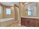 Bright bathroom with wood cabinets, soaking tub, and a separate shower at 844 E County Down Dr, Chandler, AZ 85249