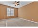 A standard bedroom with plush carpet, neutral colored walls, a ceiling fan and a light-filled window at 844 E County Down Dr, Chandler, AZ 85249