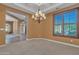 Spacious living room with tan walls and carpet, a chandelier, and plantation shutters at 844 E County Down Dr, Chandler, AZ 85249