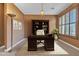 An elegant office space with rich wood finishes, a built-in bookcase, and carpet providing a professional ambiance at 844 E County Down Dr, Chandler, AZ 85249