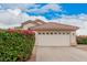 Close up of a two-car garage and desert landscaping under a partly cloudy, blue sky at 1019 N Monterey St, Gilbert, AZ 85233