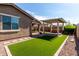 Beautiful backyard with artificial turf, covered patio, and hot tub area at 10307 E Tiburon Ave, Mesa, AZ 85212