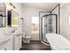 A modern bathroom featuring double sinks, a glass shower, and soaking tub at 10358 N 78Th Ave, Peoria, AZ 85345