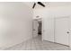 A bright room features tile floors, a ceiling fan, a closet and a door to a bathroom at 10358 N 78Th Ave, Peoria, AZ 85345