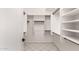 Spacious walk-in closet with custom shelving and white tile flooring at 10358 N 78Th Ave, Peoria, AZ 85345