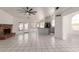 Open living area with a brick fireplace, tile floors, a ceiling fan, and access to the kitchen and backyard at 10358 N 78Th Ave, Peoria, AZ 85345